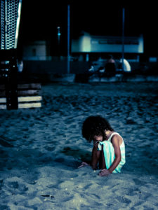 bambina che gioca nella sabbia all'imbrunire (ravenna)